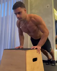 O Luca com as mãos num caixote de madeira e o corpo inclinado, na posição de cima da flexão.