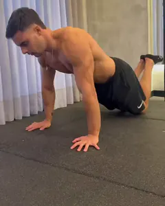 O Luca na flexão de joelhos, com os braços estendidos e os pés para cima.