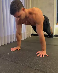 O Luca na flexão normal, com as mãos e os pés no chão e os braços estendidos.